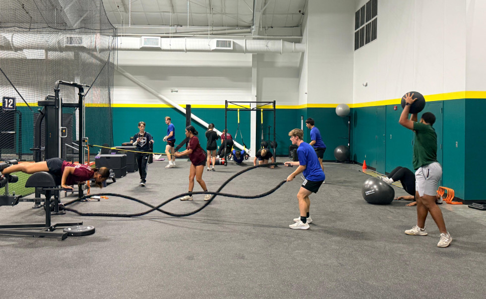 Several people exercise in a gym Several people exercise in a gym